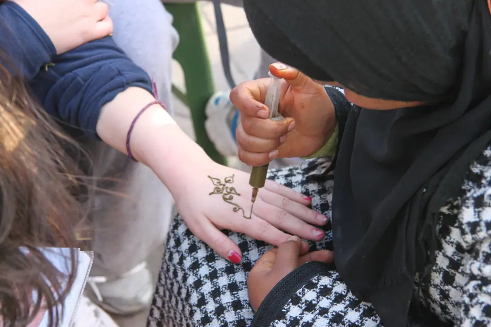 Aplicando henna con cono sobre la mano de una persona