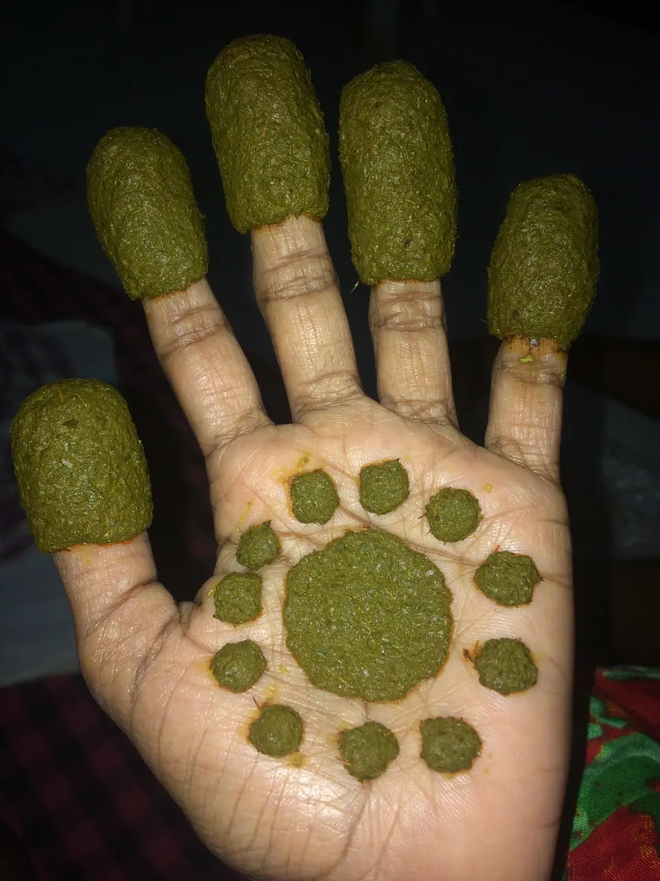 Pasta de henna fresca aplicada en la palma de la mano, aún sin remover