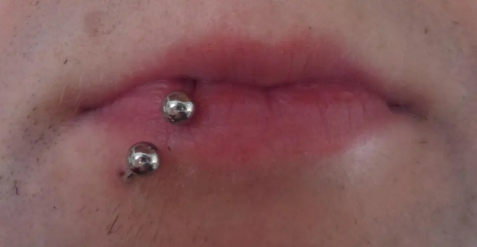 Piercing labret en el labio inferior con dos joyas de bola