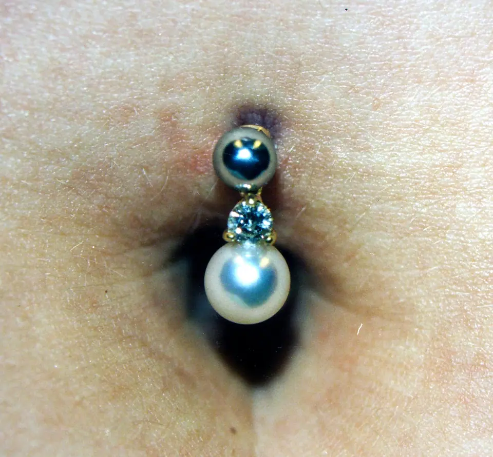 Piercing de ombligo con joya tipo perla colgante