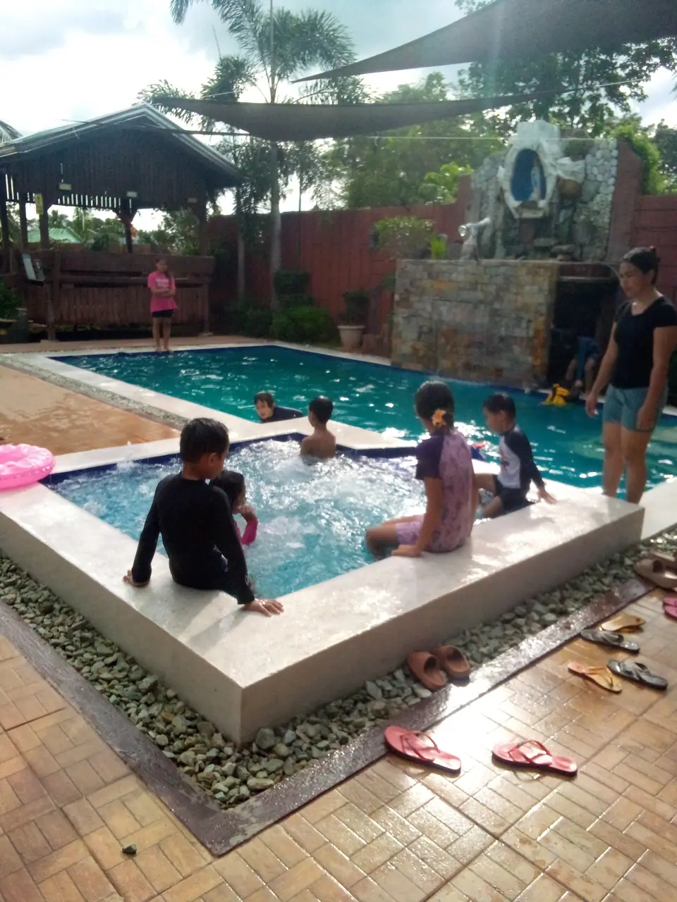 Piscina al aire libre con chicos bañándose