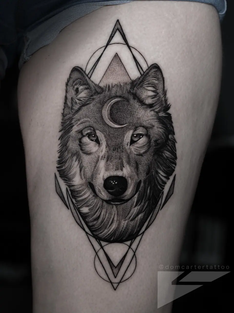 Tatuaje de lobo con luna creciente en el muslo, estilo fine line