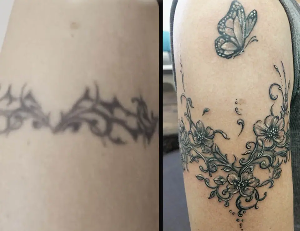 Tatuaje tribal borroso y envejecido cubierto con un nuevo diseño de flores de cerezo