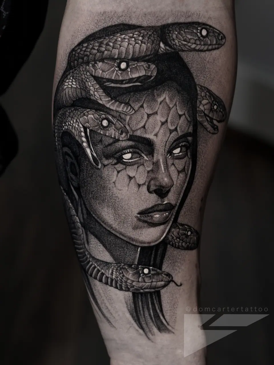 Tatuaje en blanco y negro de Medusa con serpientes en el brazo