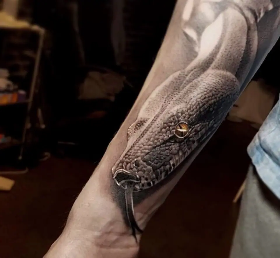 Tatuaje realista de serpiente en el antebrazo