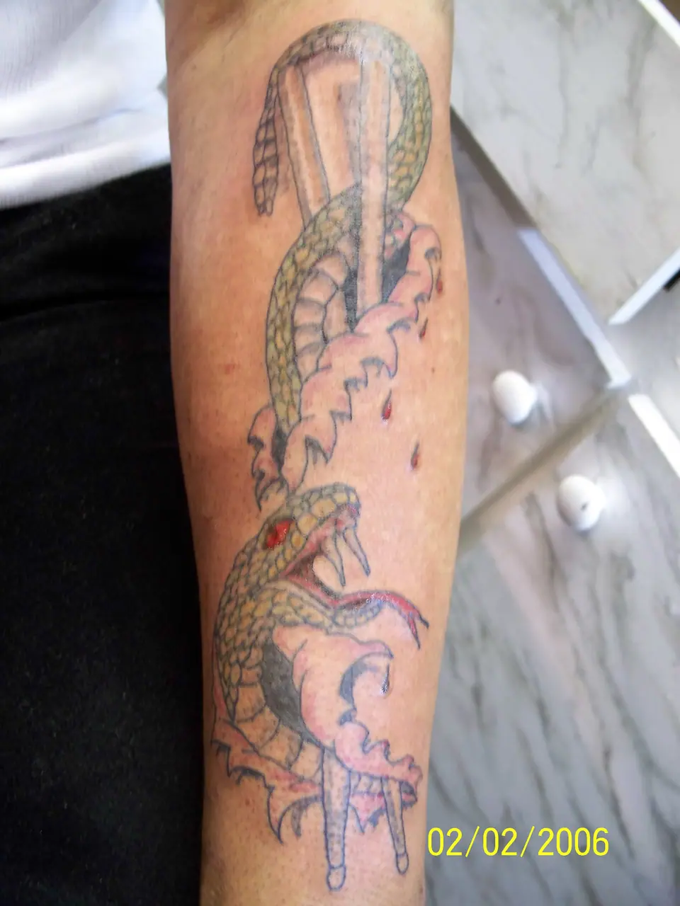 Tatuaje tradicional de dos serpientes en el antebrazo