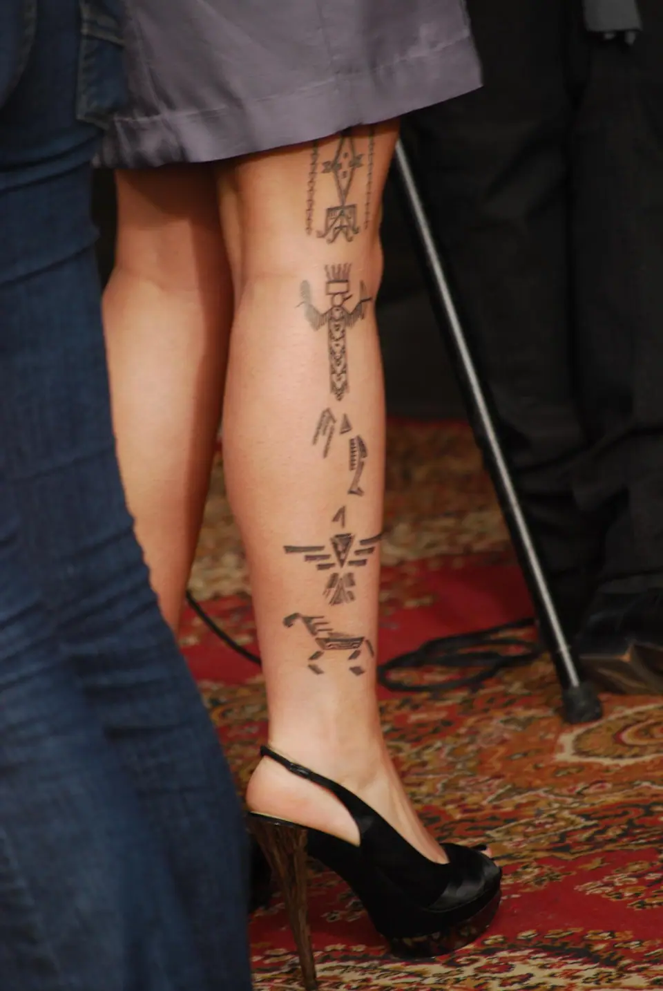 Tatuaje de símbolos en la pierna de una persona