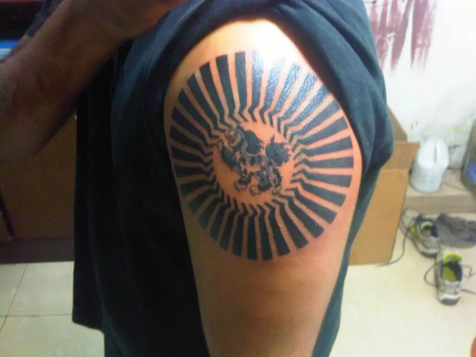 Tatuaje de sol con rayos en el hombro